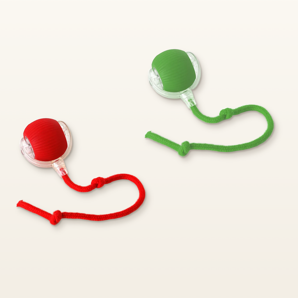 Green and red PawTec Smart Rolling Pet Balls with knotted rope tails
